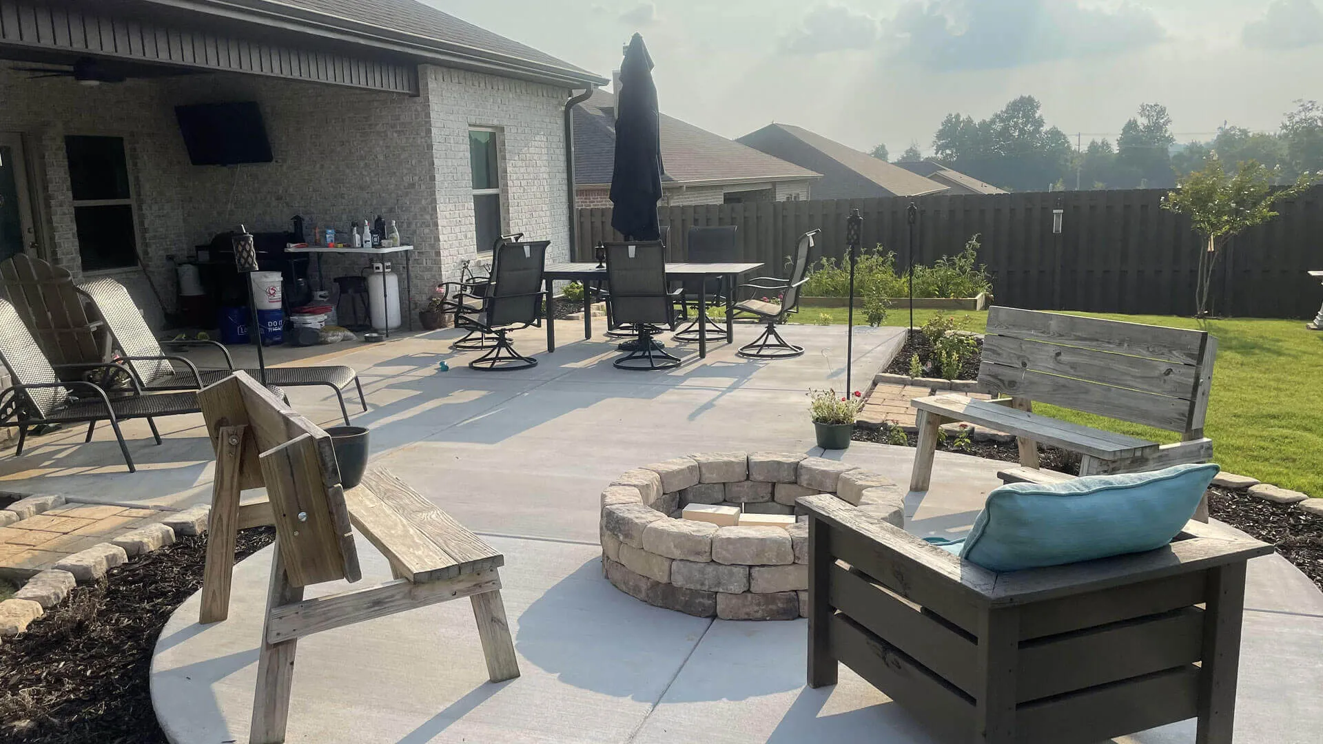 Finished concrete patio with a stone fire pit and seating area at a home in Meridianville, Alabama